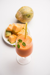 Musk melon juice with slice, also known as Kharbuj/kharbuja fruit extract, served in a glass with mint. selective focus
