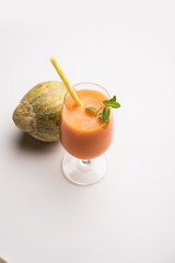 Musk melon juice with slice, also known as Kharbuj/kharbuja fruit extract, served in a glass with mint. selective focus