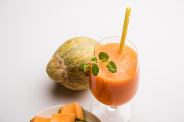 Musk melon juice with slice, also known as Kharbuj/kharbuja fruit extract, served in a glass with mint. selective focus