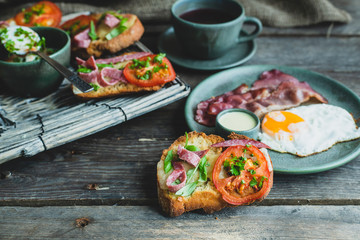 rustic breakfast, baked with basil, tomato, salami and cheese slices of bread, fried egg and bacon