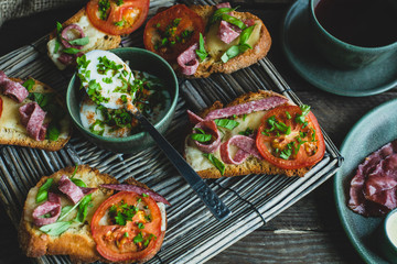 rustic breakfast, baked with basil, tomato, salami and cheese slices of bread, fried egg and bacon