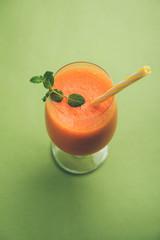 Musk melon juice with slice, also known as Kharbuj/kharbuja fruit extract, served in a glass with mint. selective focus
