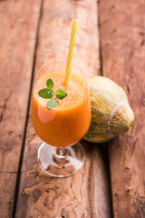 Musk melon juice with slice, also known as Kharbuj/kharbuja fruit extract, served in a glass with mint. selective focus