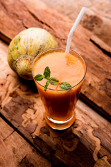 Musk melon juice with slice, also known as Kharbuj/kharbuja fruit extract, served in a glass with mint. selective focus