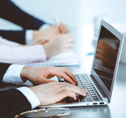 Group of business people working together in office. Man hands typing on laptop computer