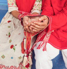 Fototapeta na wymiar hands holding Russian braided belt on the background of Russian folk clothing
