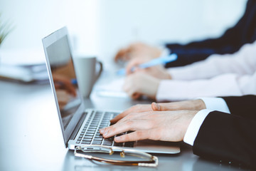 Group of business people working together in office. Man hands typing on laptop computer