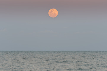 Close-up of full moon over the sea.