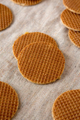 Sweet homemade dutch stroopwafels with honey-caramel filling on cloth, low angle view. Close-up.