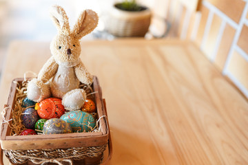 Easter bunny and colorful red and blue eggs in the basket on wood background. place for text . happy easter celebration card
