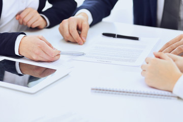Group of business people and lawyers discussing contract papers sitting at the table, close-up. Successful teamwork, cooperation and agreement concepts