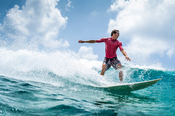 Surfer rides the wave at sunny day - obrazy, fototapety, plakaty