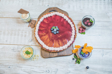 Fresh blueberry, raspberry, earthy, strawberry desserts in a rustic style on the table. View from the top