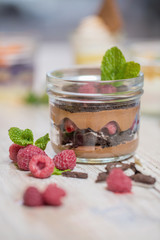 Chocolate pudding with raspberries and chia seeds, decorated with mint. crumbs of biscuits, berries, dessert layers, Ga wooden rustic table