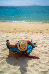Fototapeta na wymiar Woman enjoying her holidays on a transat at the tropical beach