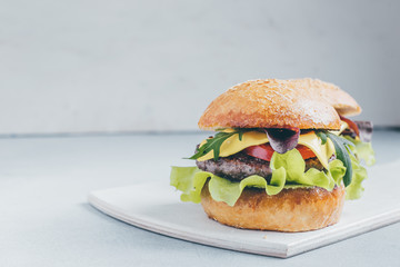 Hamburger with beef, tomatoes, cheese, lettuce, spinach, arugula and onions
