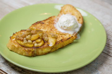 French toast with ice cream and baked apples slices and raisins