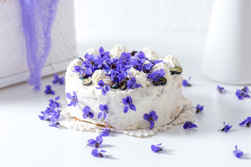 Delicious home-baked cream cake decorated with fresh violets (baked by Alina Tschemernjak)