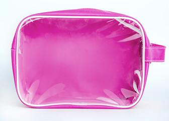 Make up bag with cosmetic products spilling out on to a pastel background