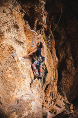 A girl climbs a rock.