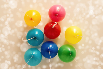 Multi colored helium balloons under ceiling of room.  