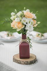 Wedding floral table decoration with candles in transparent vases
