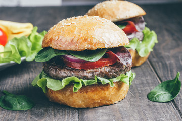 Hamburger with beef, tomatoes, cheese, lettuce, spinach, arugula and onions 