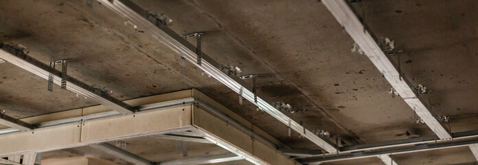 Obraz premium Installing metal profile ceiling during the repair in the living room