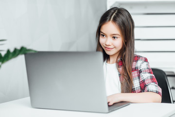Great day. Attractive inspired dark-eyed dark-haired girl  while sitting at  notebook the table at home!