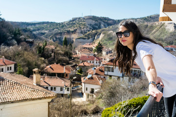Beautiful  Young Woman Sitting Above the City of Melnik in Bulgaria . Traveling Concept 