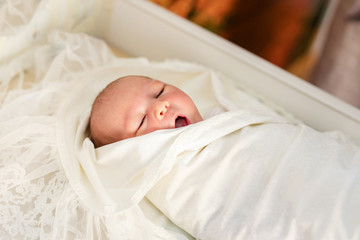 Newborn baby in his baby coat in Hospital after delivery. Bedding for kids. Infant napping in bed. Healthy little kid shortly after birth