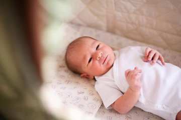 Newborn baby boy in bed. New born child in white bodykit lying in light cradle. Children sleep. Bedding for kids. Infant napping in bed. Healthy little kid shortly after birth
