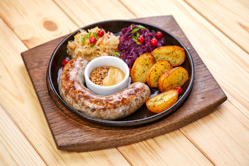 sausage with baked potatoes and salad on the wooden background