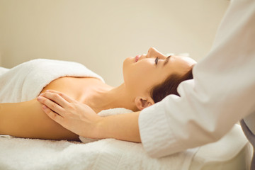 Beautiful woman is lying on the massage desk in the spa salon.