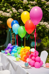Birthday table with rainbow balloons. Summer holiday in the park