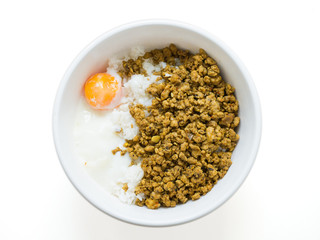 minced pork stir with yellow and Poached egg over steam rice in white bowl