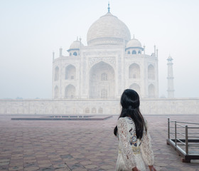 Obraz premium woman with white long dress in Taj Mahal in foggy morning