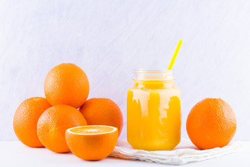 Orange fruits and juice on white background. Citrus fruit for making juice with manual juicer. Oranges on white napkin. Mason jar with orange juice