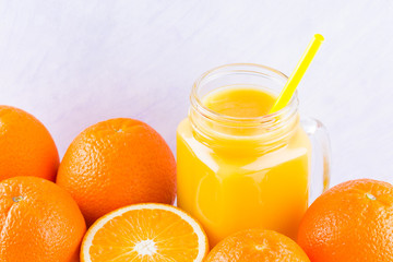 Orange fruits and juice on white background. Citrus fruit for making juice with manual juicer. Oranges on white napkin. Mason jar with orange juice