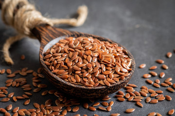 Flax seeds on wooden spoon - obrazy, fototapety, plakaty