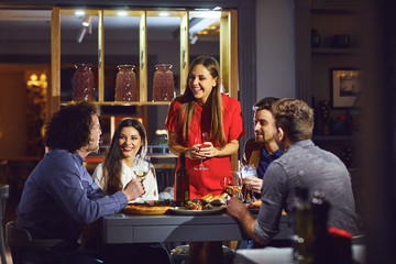 Friends at a party in a restaurant talking at the table