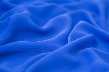 Silk crumpled fabric blue. View from above. Textile and texture concept - close up of crumpled silk blue wavy fabric background