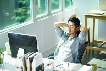 young asian businessman thinking in office