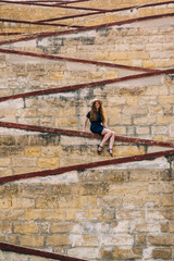 Young girl sitting on the city walls, old city of the Threee Cities