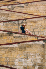 Young girl sitting on the city walls, old city of the Threee Cities