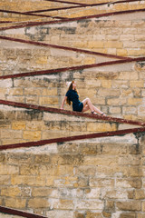 Young girl sitting on the city walls, old city of the Threee Cities