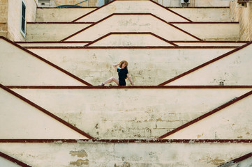 Young girl sitting on the city walls, old city of the Threee Cities
