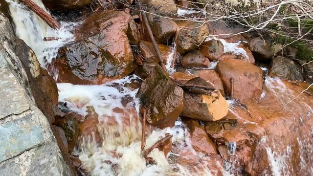 A little serene waterfall on orange rocks in Skatas, Gothenburg, Sweden