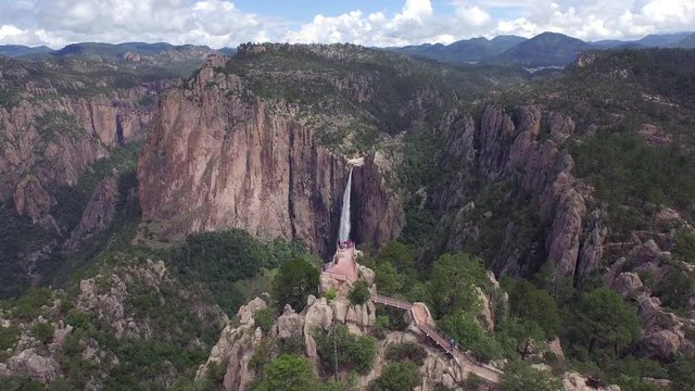 Aerial jib up shot revealing the Basaseachi waterfall behind a scenic lookout, in the Candamena Canyon, Chihuahua