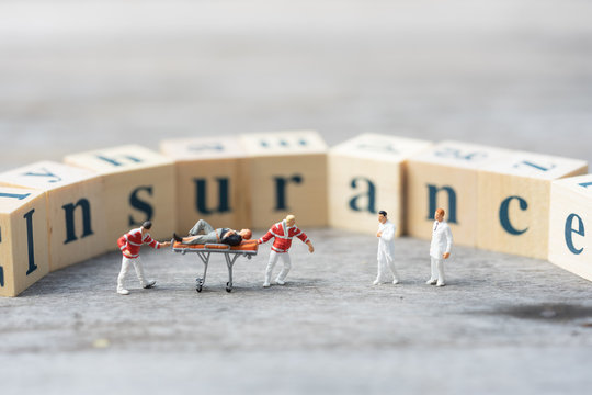 Miniature People, Emergency Medical Team With Unconcious  Patient On Word Blocks 